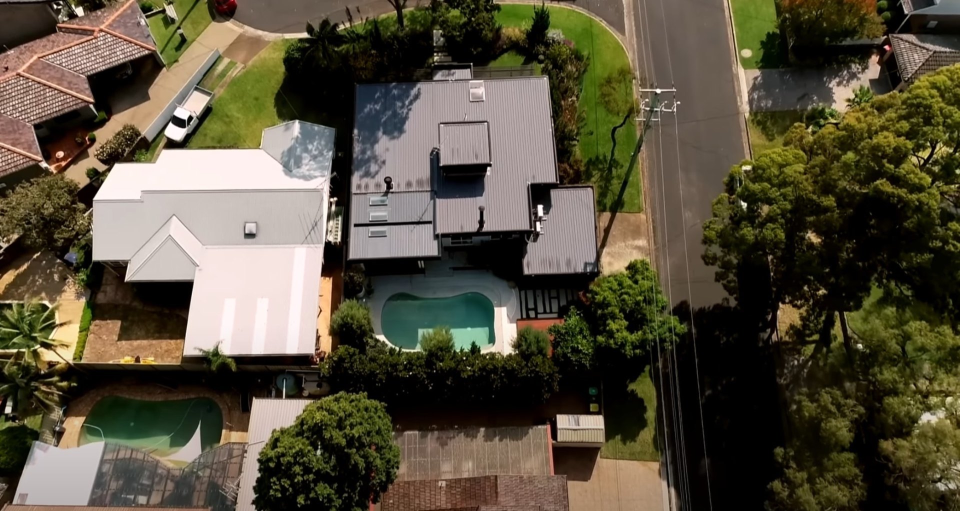Licensed landscape contractors delivering premium outdoor living spaces Aerial view of professional residential landscaping with pool and outdoor living areas
