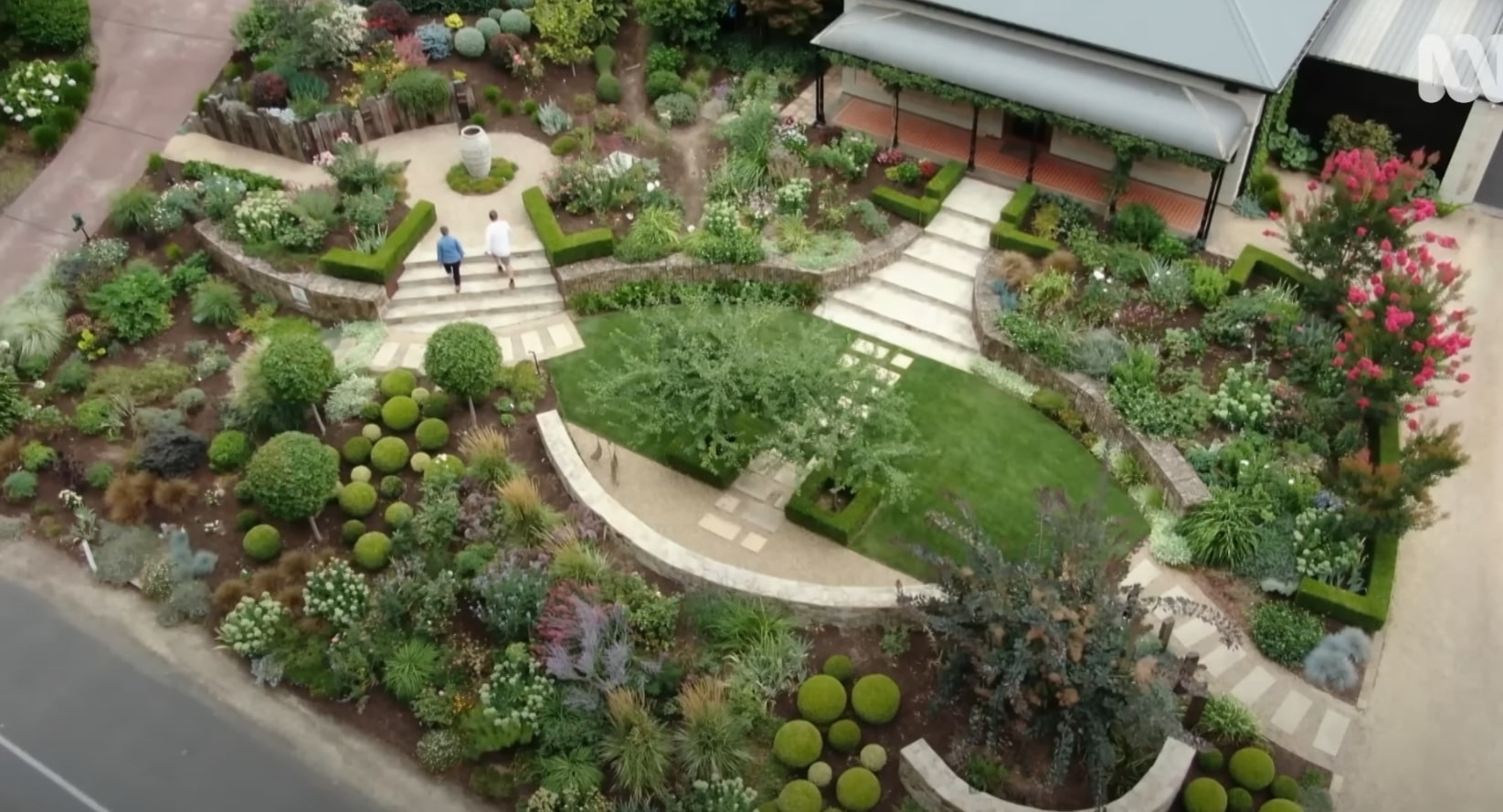 Award-winning formal garden design with intricate geometric layouts and sculptural topiary elements Aerial view of elaborate formal garden design with curved pathways, topiary spheres, and geometric planting beds showcasing professional landscape architecture